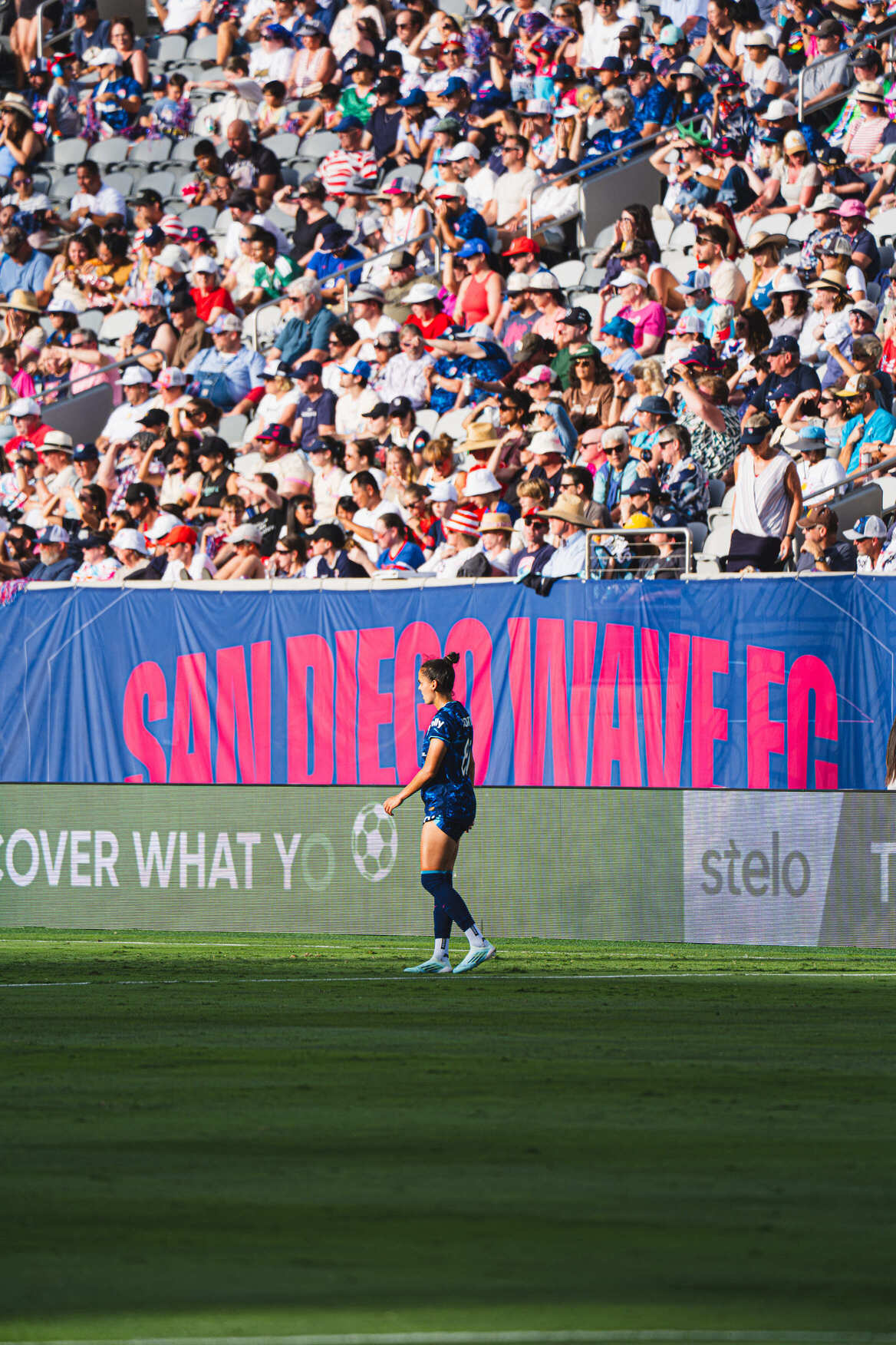 Player in blue kit celebrating with arms wide
